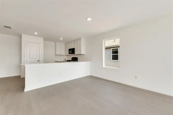 a kitchen with white cabinets and black appliances