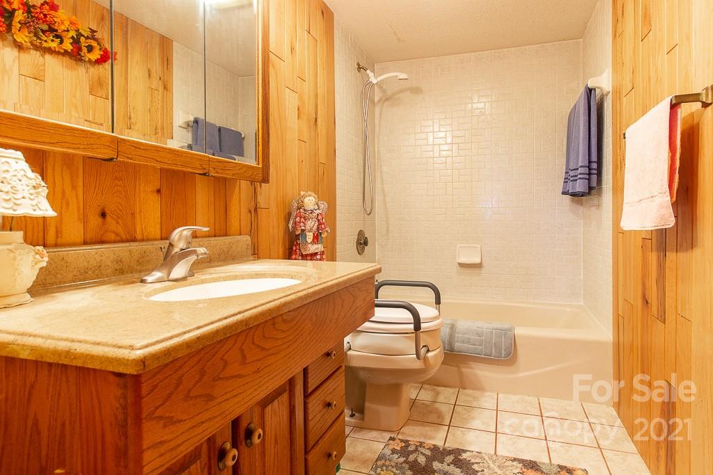 620 Pioneer Ridge Road Canton, NC 28716 - Photo 14 of 42 a bathroom with a granite countertop sink and a bathtub