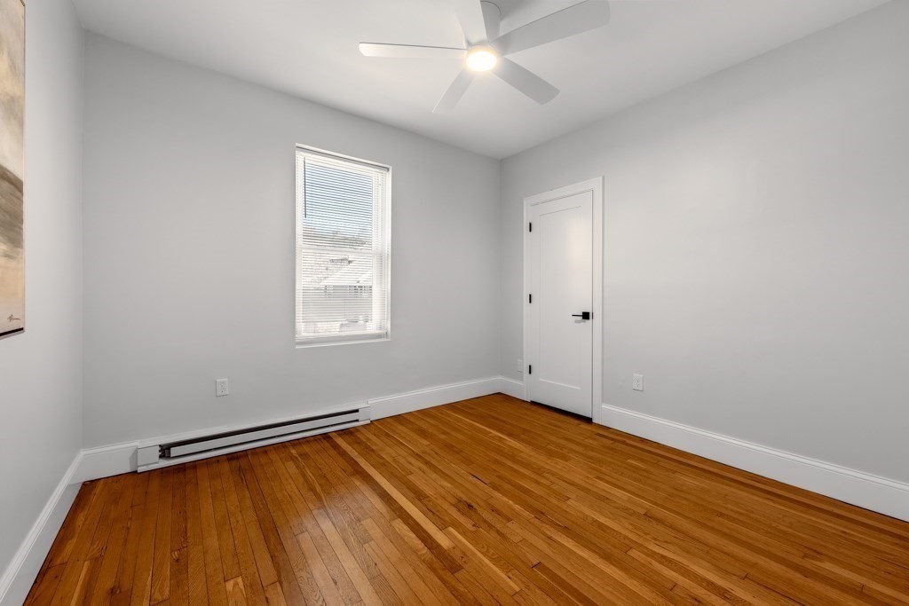 113 Regent Street Boston, MA 02119 - Photo 11 of 18 a view of a room with wooden floor and fan