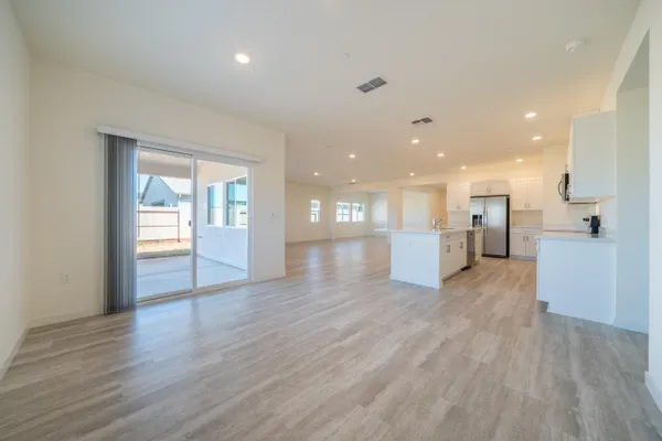 a view of a big room with wooden floor and windows