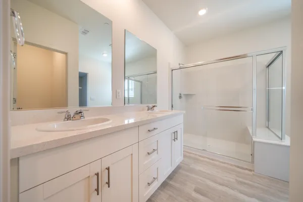 a bathroom with a double vanity sink a mirror and a shower