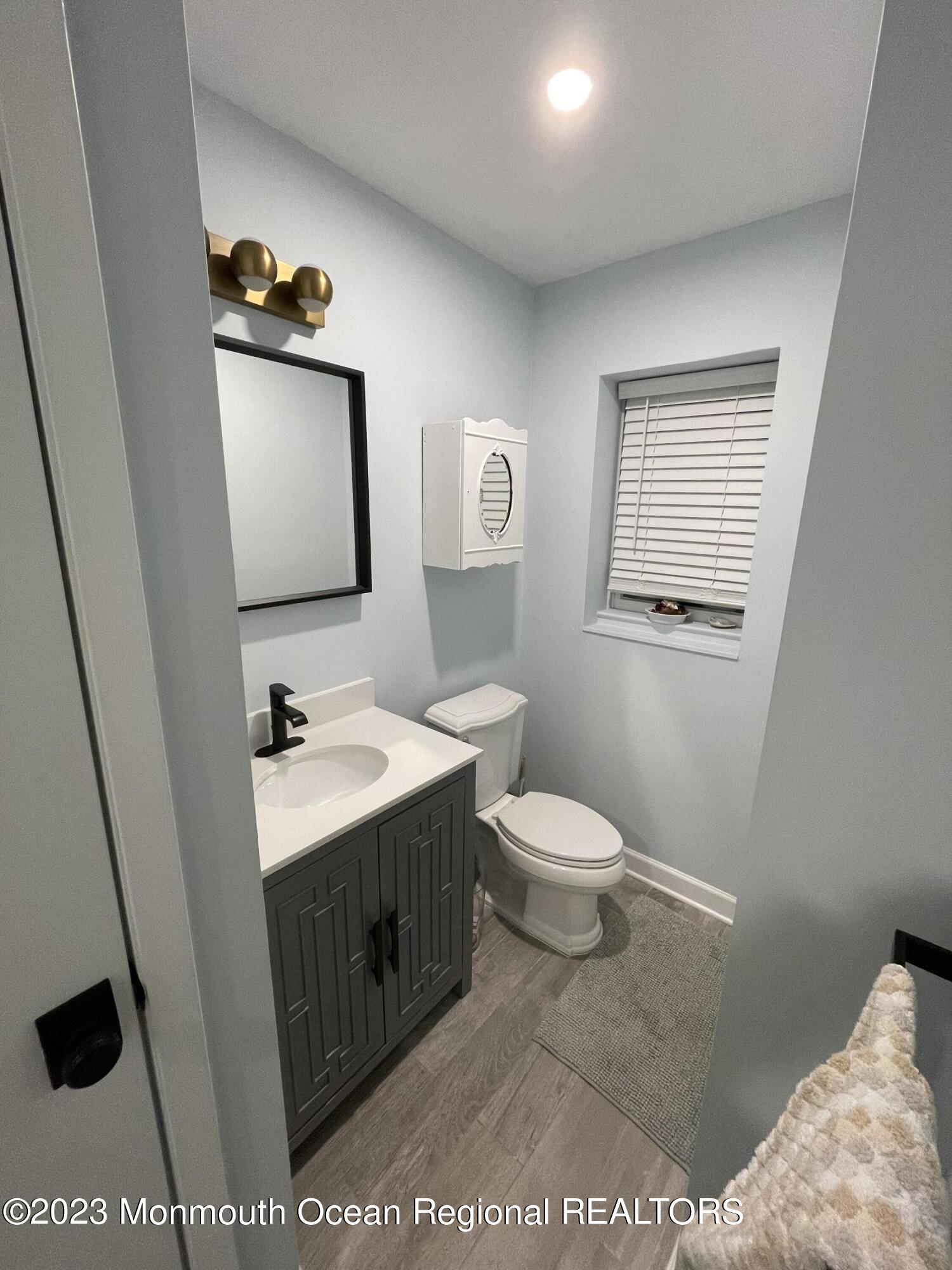 73 Cookman Avenue, Unit A Ocean Grove, NJ 07756 - Photo 19 of 20 a bathroom with a sink a toilet and mirror