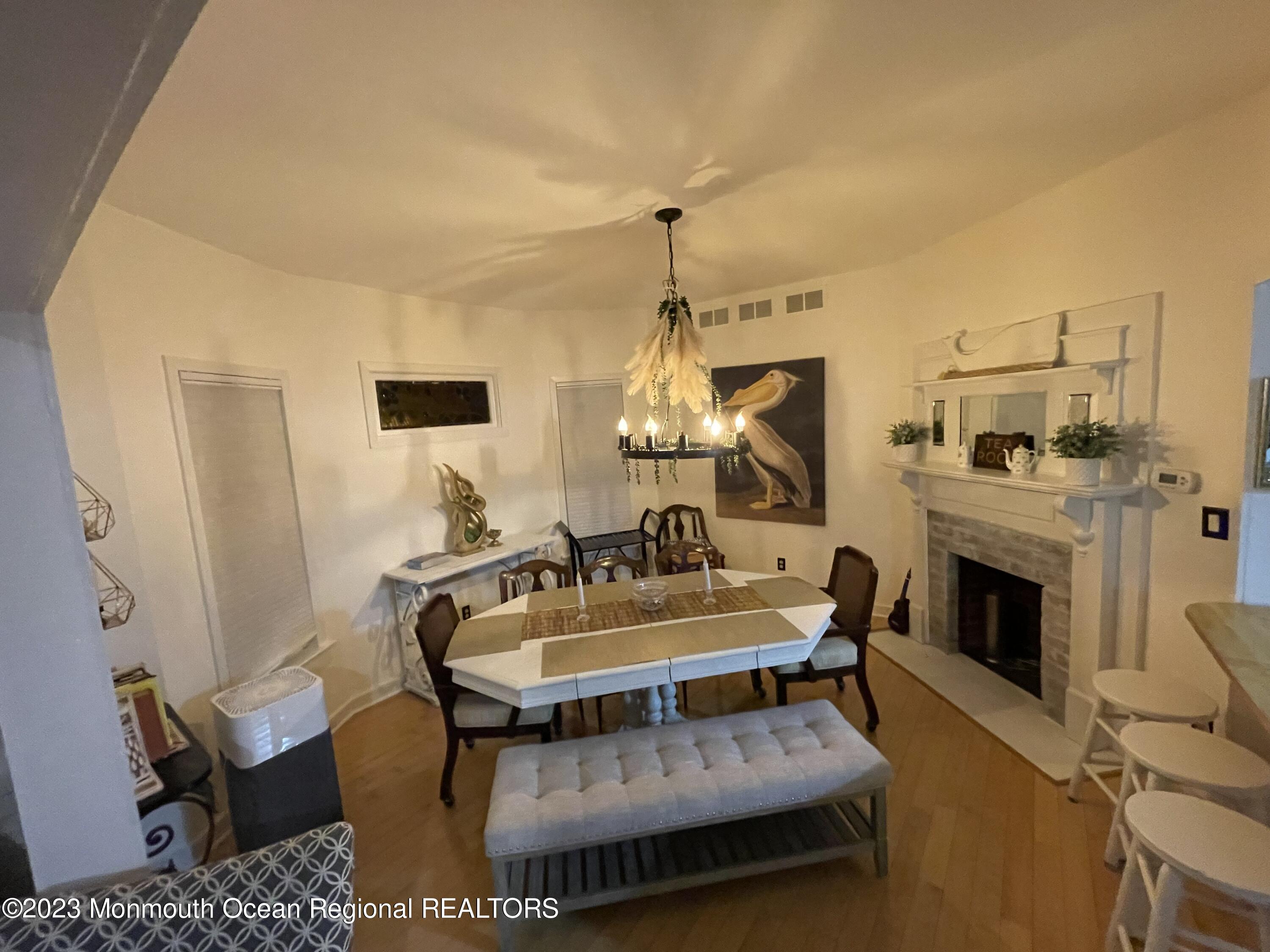 73 Cookman Avenue, Unit A Ocean Grove, NJ 07756 - Photo 10 of 20 a living room with furniture a fireplace and a chandelier