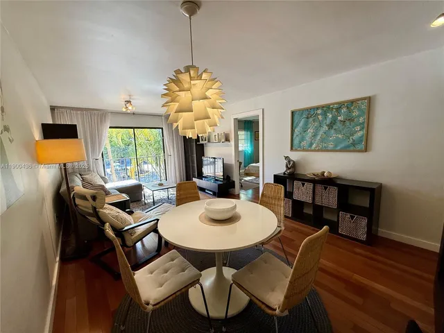 a view of a dining room with furniture a chandelier and wooden floor
