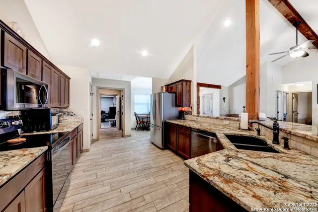 a large kitchen with stainless steel appliances kitchen island granite countertop a large counter top appliances and cabinets