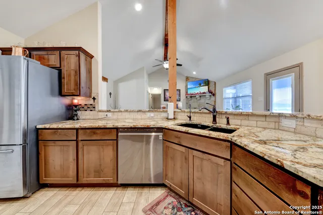 a kitchen with stainless steel appliances granite countertop a sink stove and refrigerator