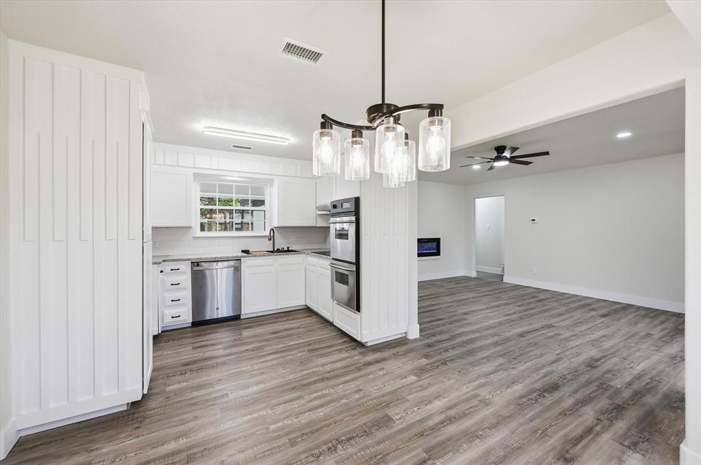 2804 Bent Tree Lane Arlington, TX 76016 - Photo 13 of 32 a kitchen with stainless steel appliances a refrigerator and wooden floor
