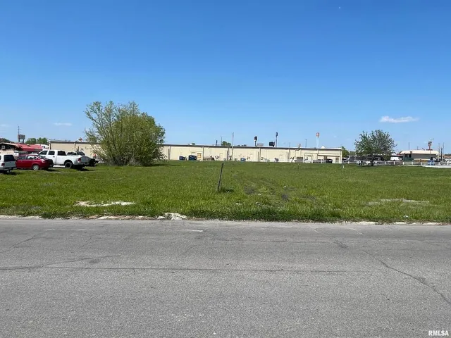 a view of a field with a building in background
