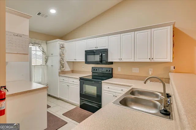 a kitchen with granite countertop a sink stainless steel appliances and cabinets