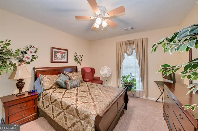 a bedroom with bed and a potted plant