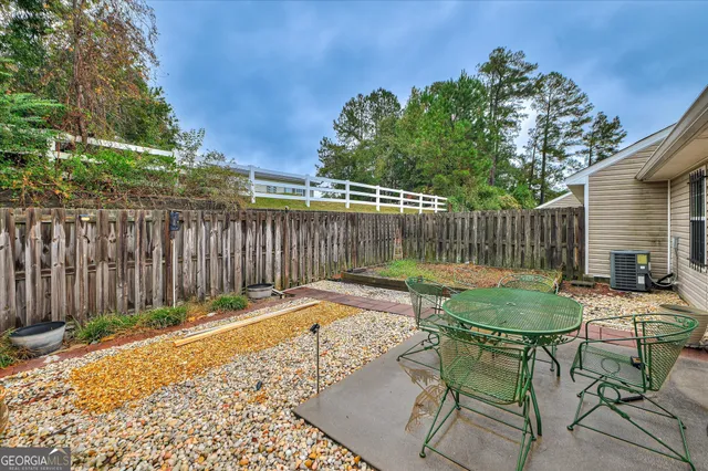 a backyard of a house with table and chairs