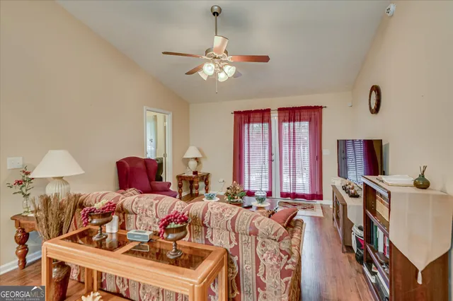 a living room with furniture a chandelier and a flat screen tv
