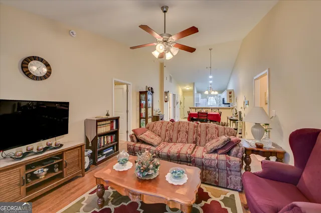 a living room with furniture a flat screen tv and a dining table
