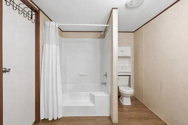 a bathroom with a shower a toilet and a shower