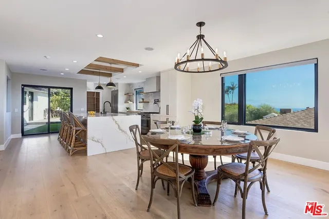 a view of a dining room and livingroom with furniture wooden floor a chandelier