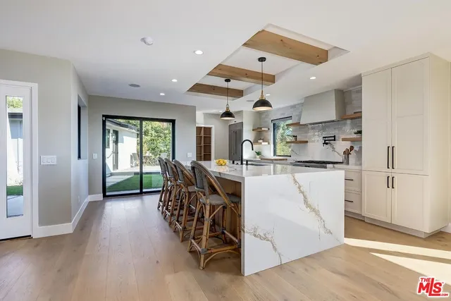 a large kitchen with stainless steel appliances a large counter top and a wooden floors