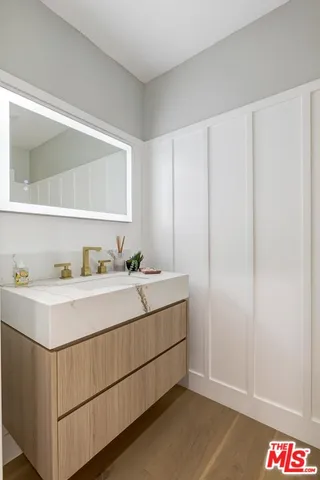 a bedroom with a large bed and wooden floor