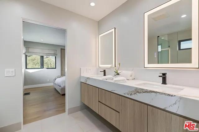 a bathroom with a double vanity sink mirror and shower