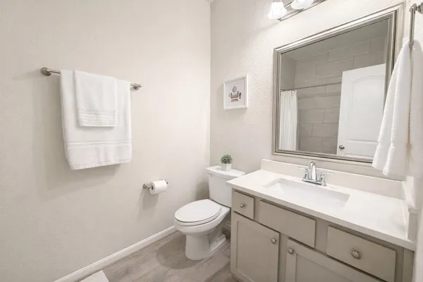 a bedroom with a bed a table and painting on the wall