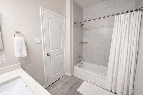 a bedroom with a bed and flat tv with wooden floor