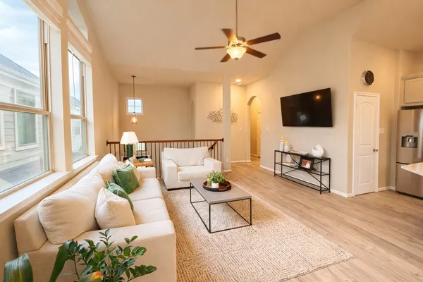 a kitchen with stainless steel appliances a refrigerator a stove a sink dishwasher and white cabinets with wooden floor