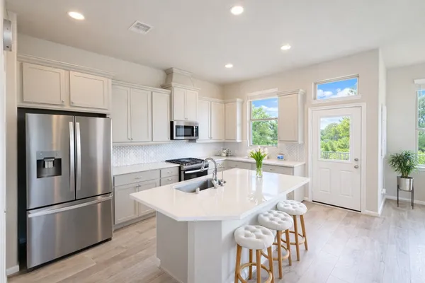a kitchen with sink refrigerator and large window