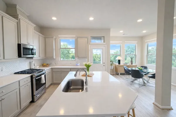 a kitchen with a sink stove and white cabinets