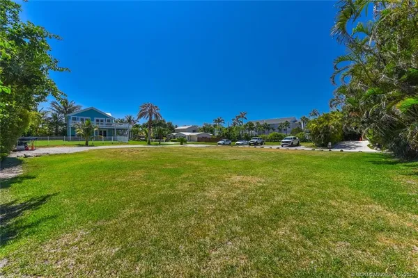 a view of a green field with trees in the background