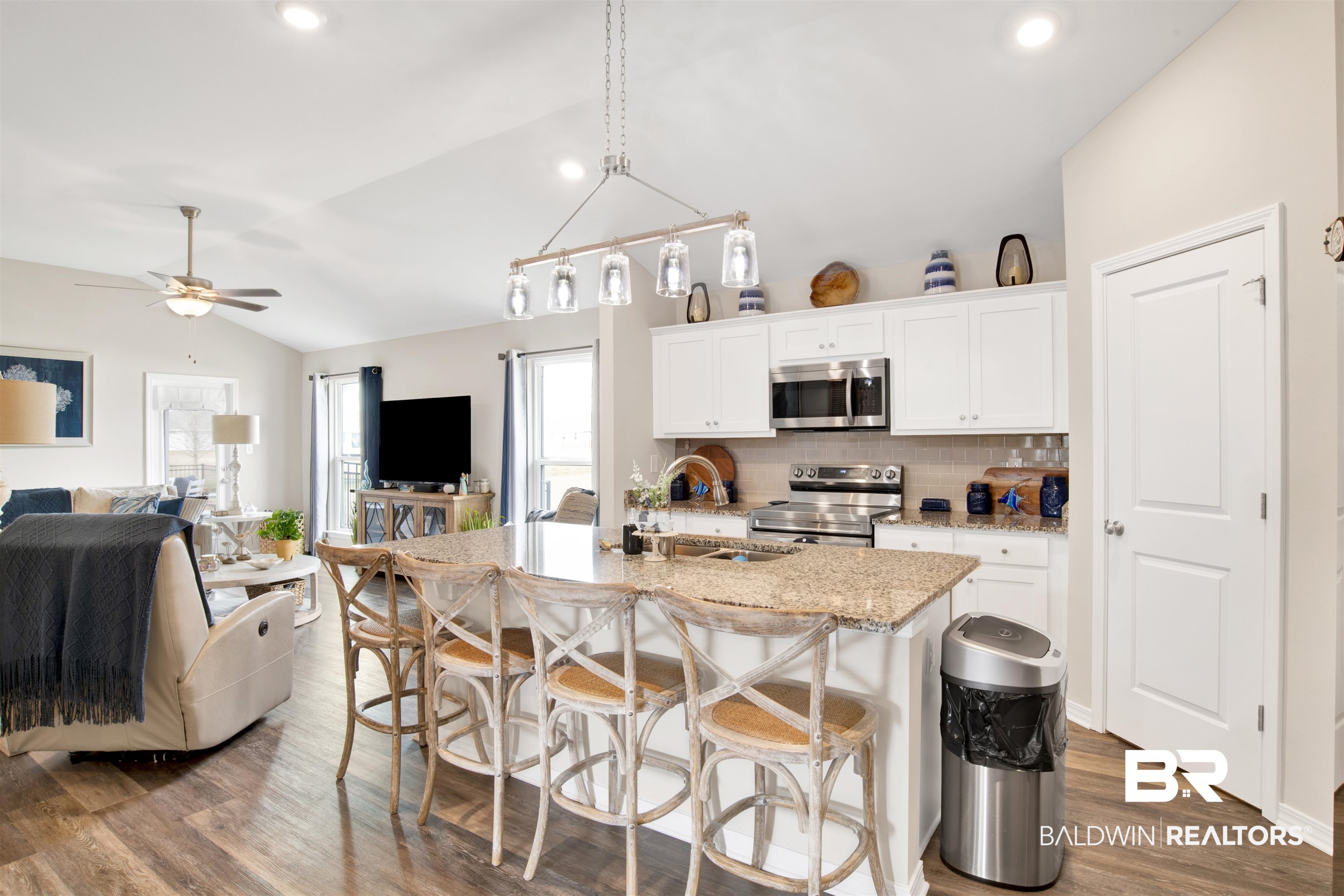3097 Ingrid Lane Foley, AL 36535 - Photo 14 of 38 Kitchen with stainless steel appliances, white cabinetry, vaulted ceiling, and a kitchen island with sink