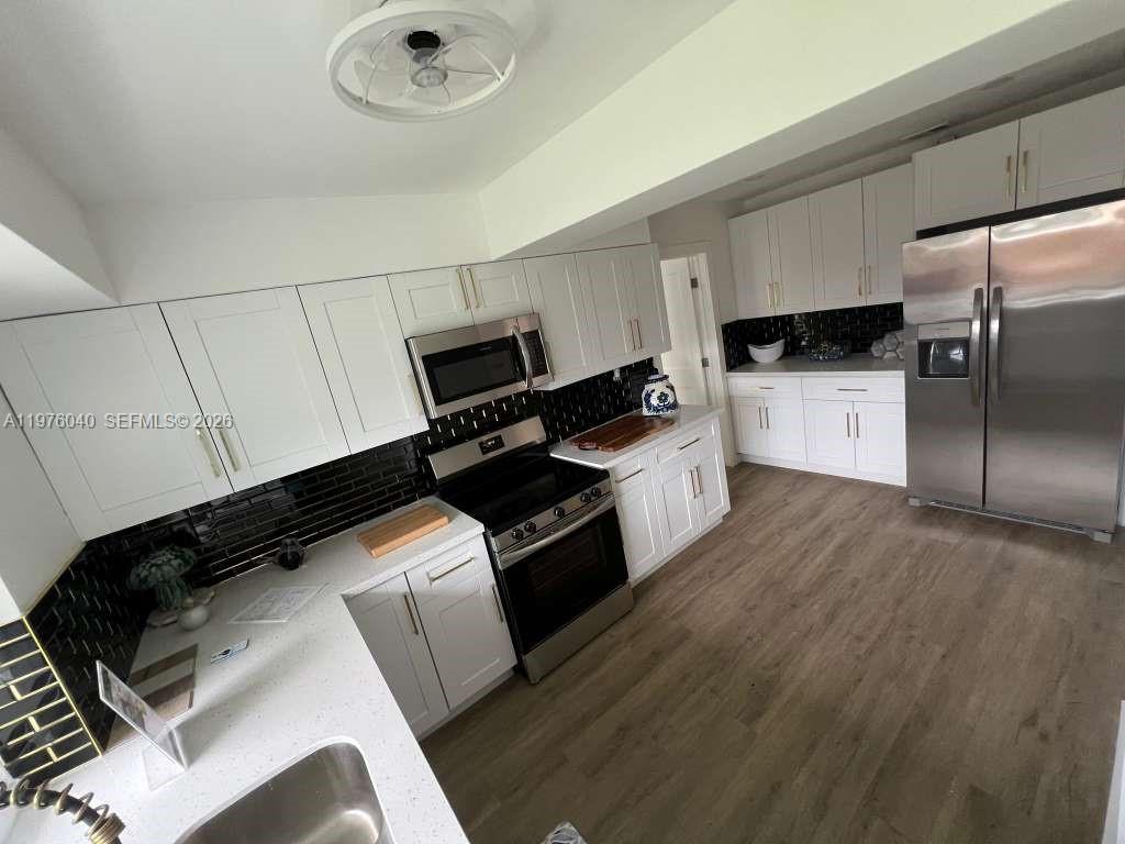 6220 Northwest 19th Street Sunrise, FL 33313 - Photo 12 of 21 a kitchen with a refrigerator and white cabinets