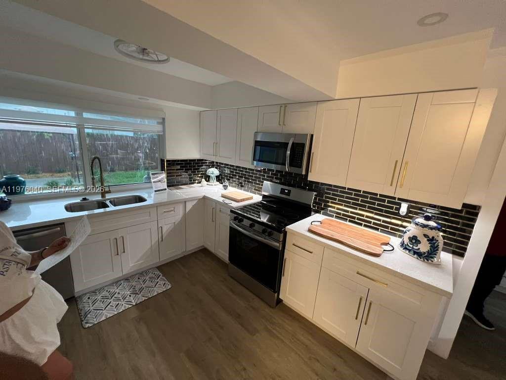 6220 Northwest 19th Street Sunrise, FL 33313 - Photo 17 of 21 a kitchen with a stove a sink and a microwave