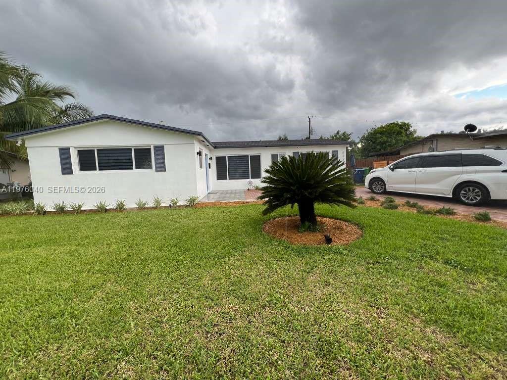 6220 Northwest 19th Street Sunrise, FL 33313 - Photo 2 of 21 a front view of a house with garden