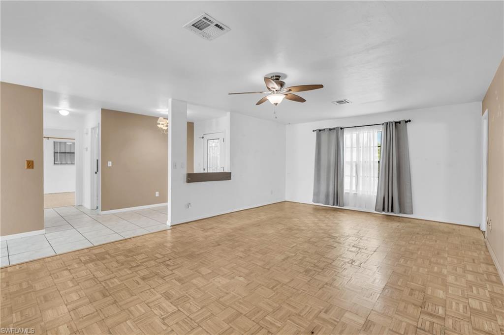 2264 53rd Street Southwest Naples, FL 34116 - Photo 13 of 40 Unfurnished room with ceiling fan with notable chandelier and light parquet floors