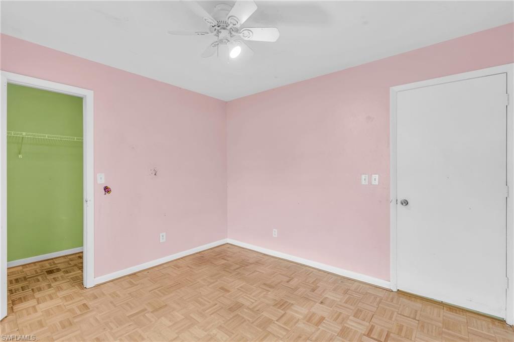 2264 53rd Street Southwest Naples, FL 34116 - Photo 24 of 40 Unfurnished bedroom with light parquet flooring, a walk in closet, and ceiling fan