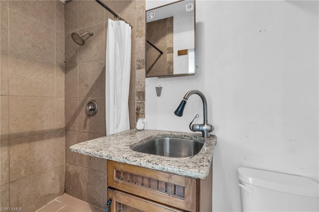 2264 53rd Street Southwest Naples, FL 34116 - Photo 31 of 40 Bathroom with vanity, toilet, and curtained shower