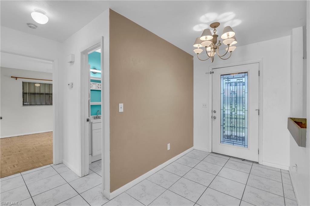 2264 53rd Street Southwest Naples, FL 34116 - Photo 10 of 40 Foyer with a notable chandelier and light parquet flooring