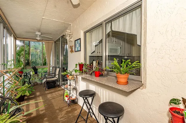 a view of porch with a table and chairs and potted plants
