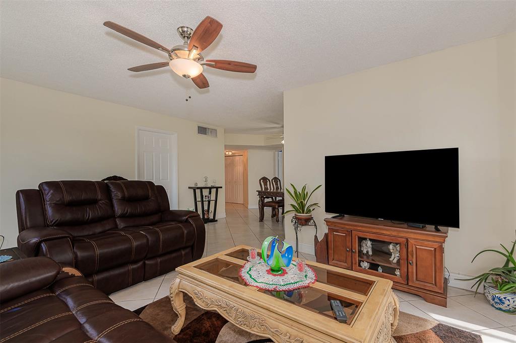 9351 Lime Bay Boulevard, Unit 207 Tamarac, FL 33321 - Photo 6 of 27 a living room with furniture and a flat screen tv