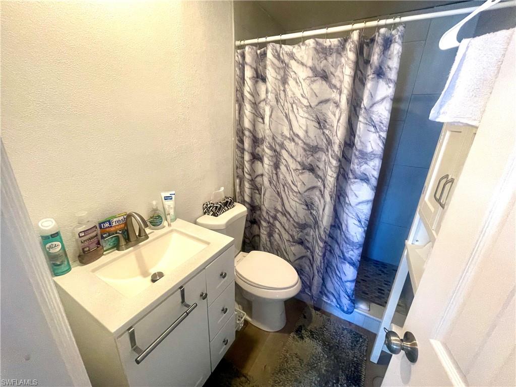 1339 5th Avenue North Naples, FL 34102 - Photo 14 of 17 Full bath with vanity, a shower stall, and a textured wall