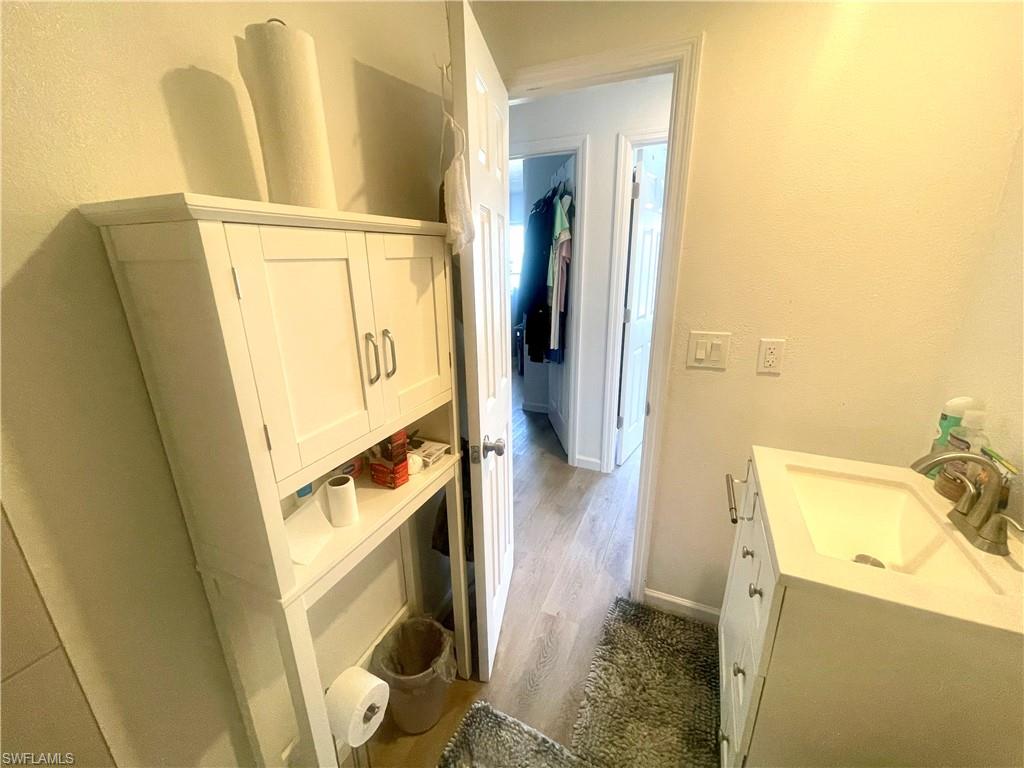 1339 5th Avenue North Naples, FL 34102 - Photo 15 of 17 Bathroom with vanity, a textured wall, and dark wood-style flooring