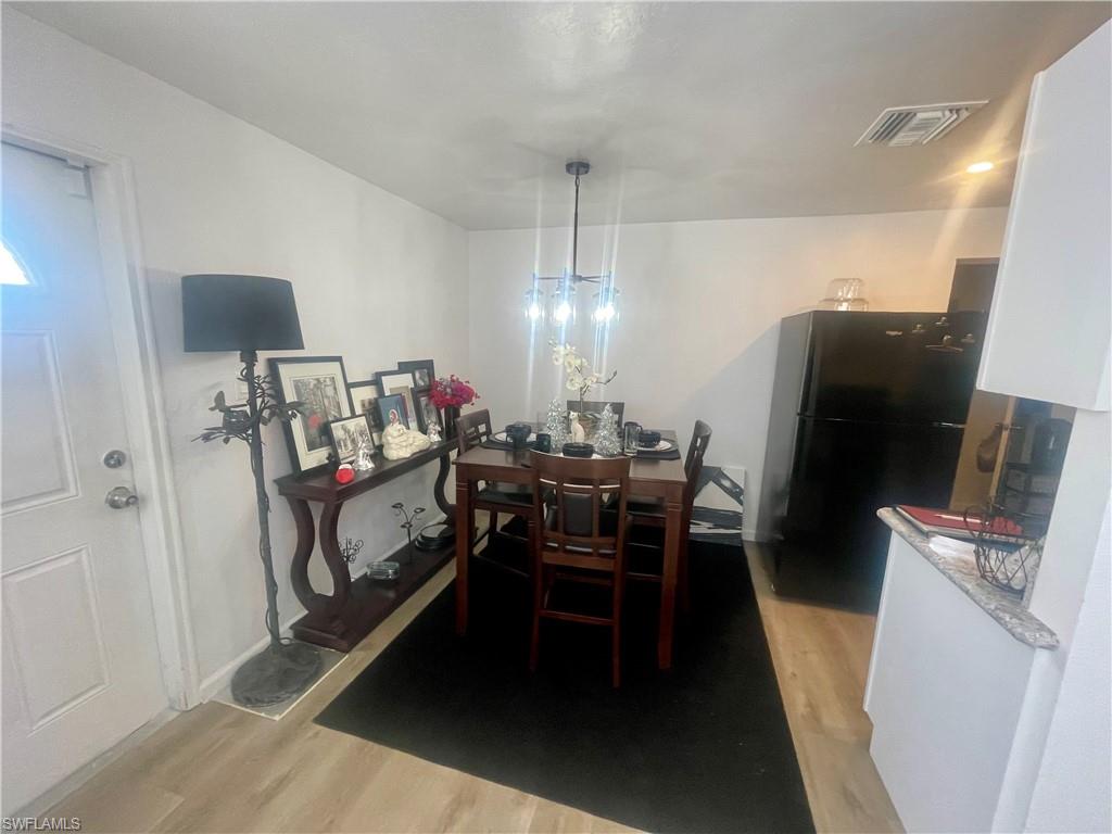 1339 5th Avenue North Naples, FL 34102 - Photo 4 of 17 Dining area with light wood finished floors and a chandelier