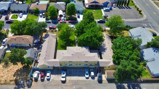 an aerial view of residential house with outdoor space and trees all around