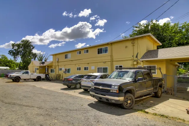 a backyard of a house with table and chairs