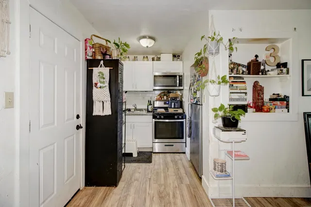 a kitchen with granite countertop white cabinets and white stainless steel appliances