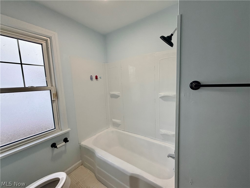 10506 Park Heights Road Cleveland, OH 44104 - Photo 13 of 22 Bathtub and shower combination featuring a white surround and a matte black shower head