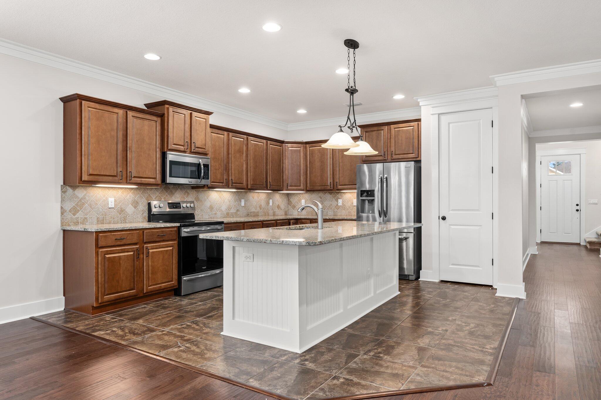 112 Blue Sage Road Panama City Beach, FL 32413 - Photo 13 of 46 a kitchen with kitchen island granite countertop wooden cabinets and stainless steel appliances