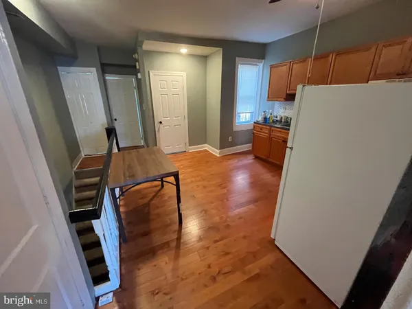a view of a kitchen with furniture and a refrigerator
