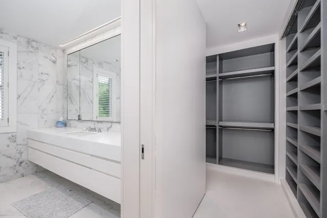 a bathroom with a double vanity sink and mirror with bathtub