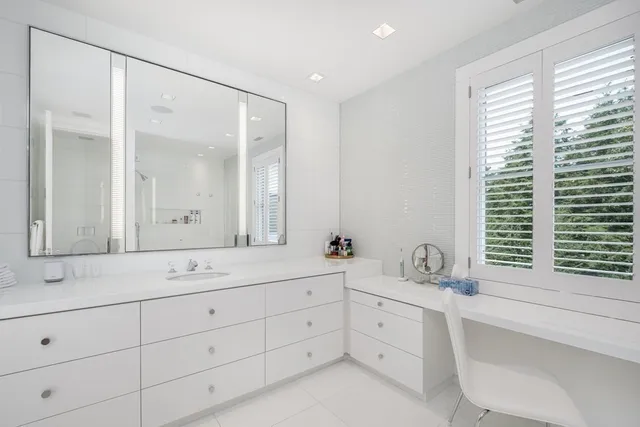 a bathroom with a double vanity sink a mirror and a window