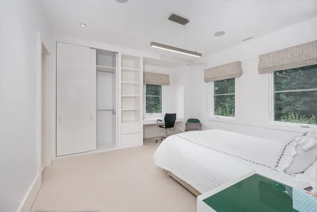 a bedroom with a bed and a large window